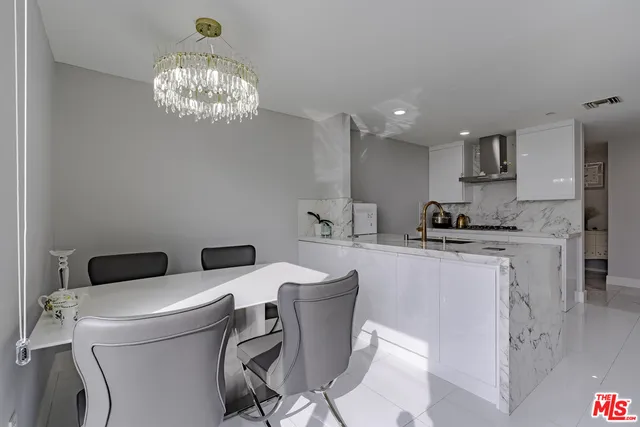 a large kitchen with kitchen island a sink a stove a dining table and chairs