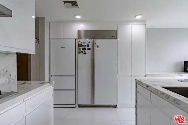 a kitchen with granite countertop white cabinets and a sink