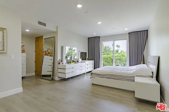 a spacious bedroom with a large bed and a dresser