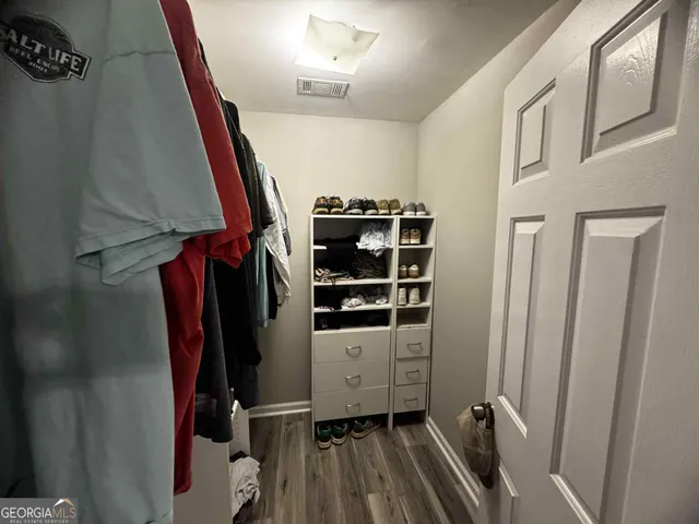 a view of walk in closet with clothes and shoes