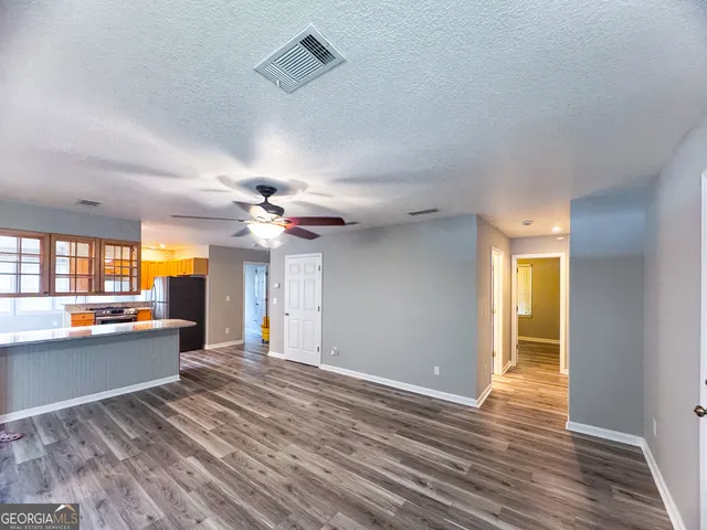 a view of a livingroom with wooden floor and a ceiling fan