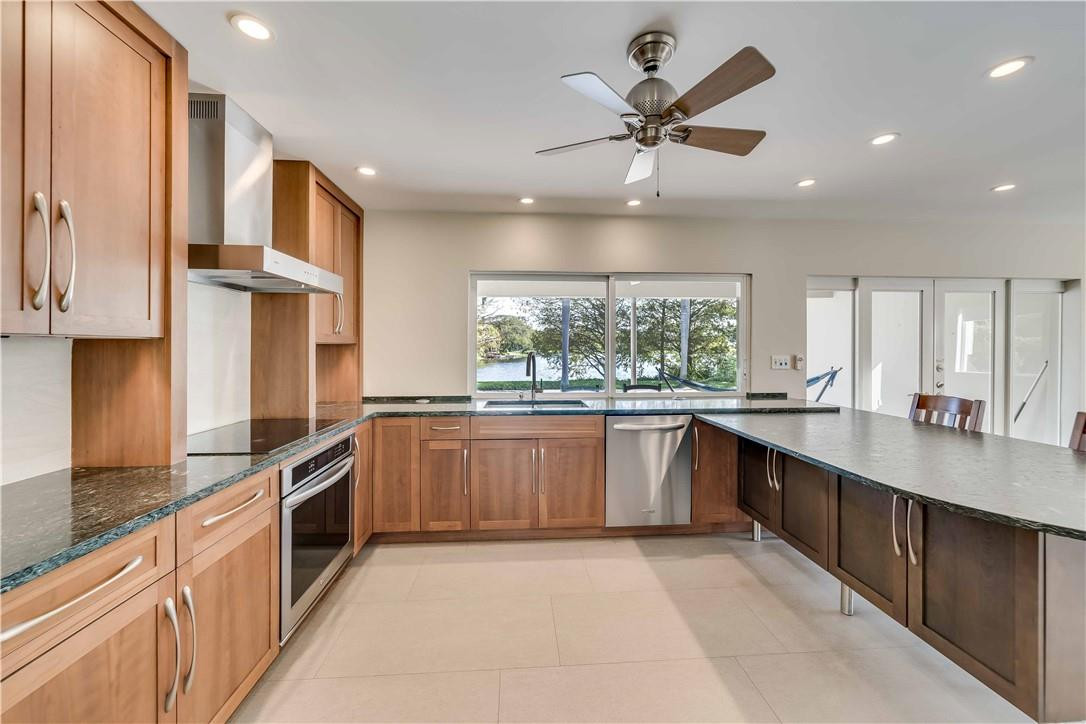 1920 Southwest 67th Terrace Plantation, FL 33317 - Photo 16 of 65 a large kitchen with stainless steel appliances granite countertop a sink and cabinets
