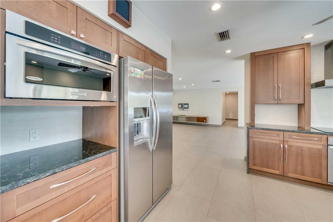 1920 Southwest 67th Terrace Plantation, FL 33317 - Photo 18 of 65 a kitchen with stainless steel appliances kitchen island granite countertop a refrigerator and a stove