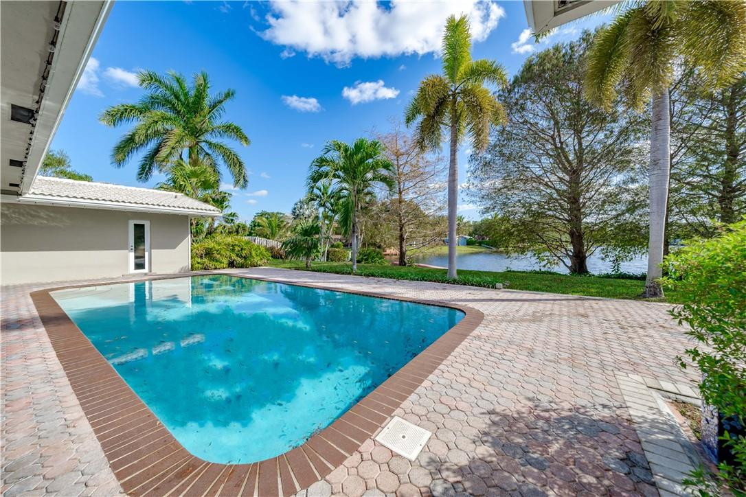 1920 Southwest 67th Terrace Plantation, FL 33317 - Photo 45 of 65 a view of a swimming pool with a patio and a yard