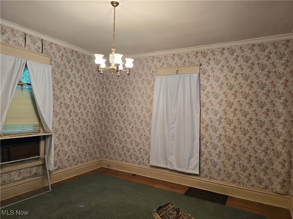 610 Dryden Road Zanesville, OH 43701 - Photo 5 of 13 Unfurnished room with a chandelier, ornamental molding, and wood finished floors