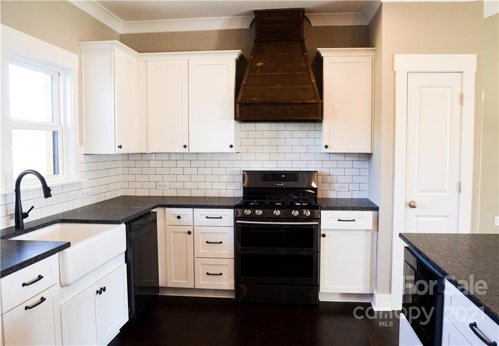 470 Cal Kennedy Road Cleveland, NC 27013 - Photo 5 of 21 a kitchen with stainless steel appliances granite countertop a sink stove and cabinets