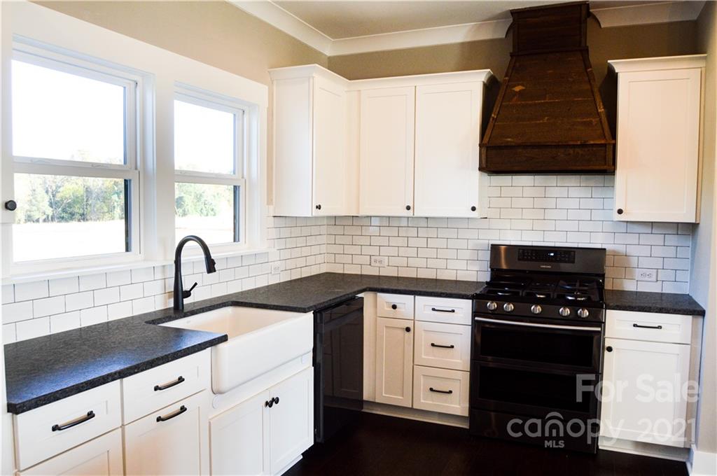470 Cal Kennedy Road Cleveland, NC 27013 - Photo 6 of 21 a kitchen with white cabinets a sink and a stove
