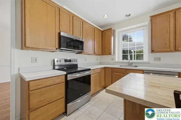 a kitchen with stainless steel appliances granite countertop a stove a sink and a microwave
