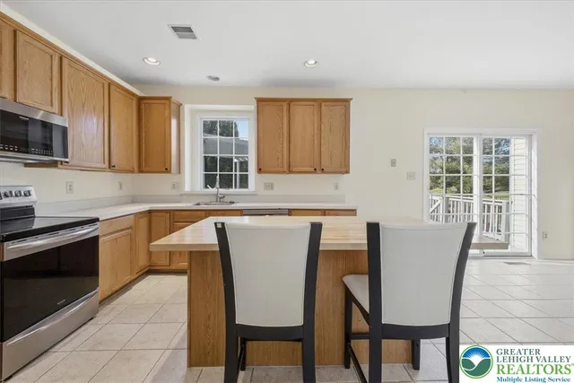 a kitchen with stainless steel appliances granite countertop a stove a sink a microwave and a refrigerator