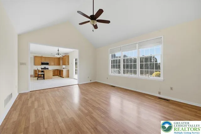a view of an empty room with a window and wooden floor