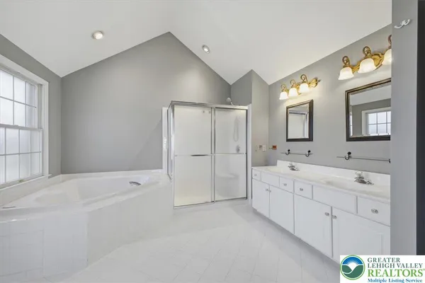 a spacious bathroom with a shower a sink and a large mirror