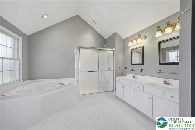a spacious bathroom with a shower a sink and a large mirror
