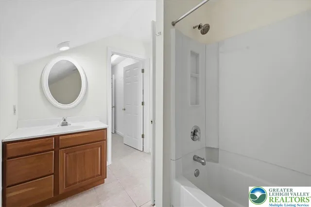 a bathroom with a tub sink and mirror