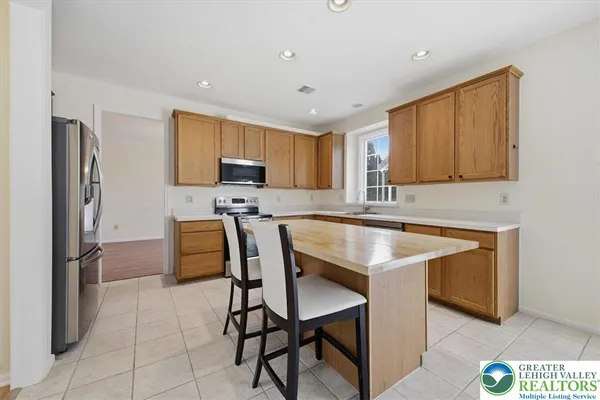 a kitchen with stainless steel appliances granite countertop a stove a sink refrigerator and a microwave