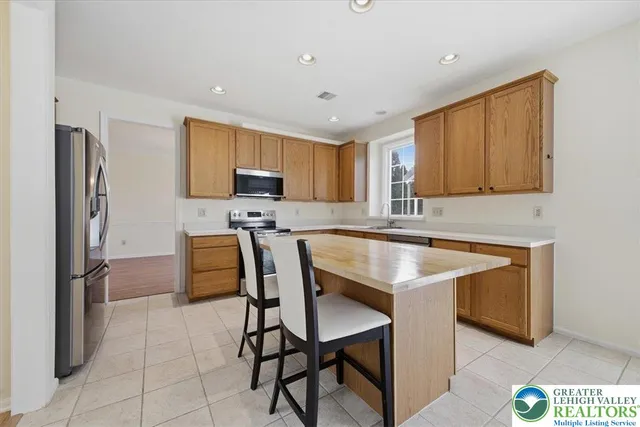 a kitchen with stainless steel appliances granite countertop a stove a sink refrigerator and a microwave