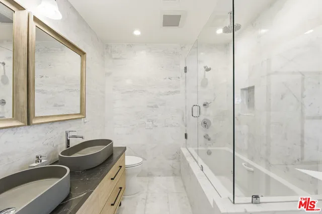 a bathroom with a granite countertop sink mirror bathtub and shower