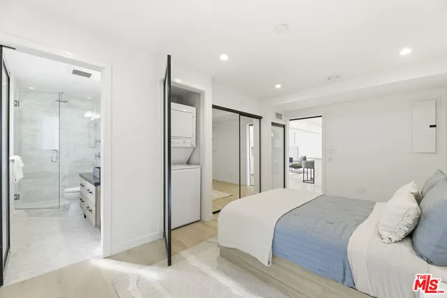 a bedroom with a bed and a glass door shower