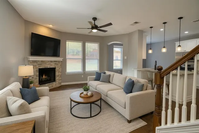 a living room with furniture a flat screen tv and a fireplace