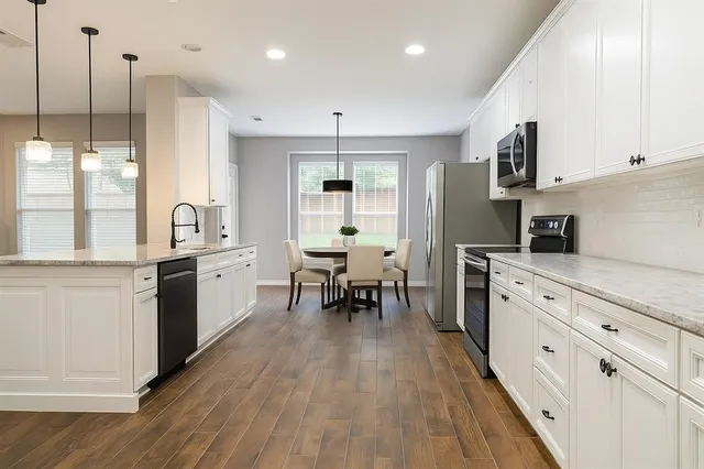 a spacious bedroom with a bed a couch and a flat screen tv