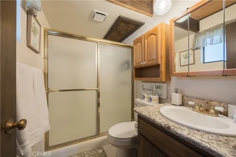 a bathroom with a granite countertop sink toilet and shower