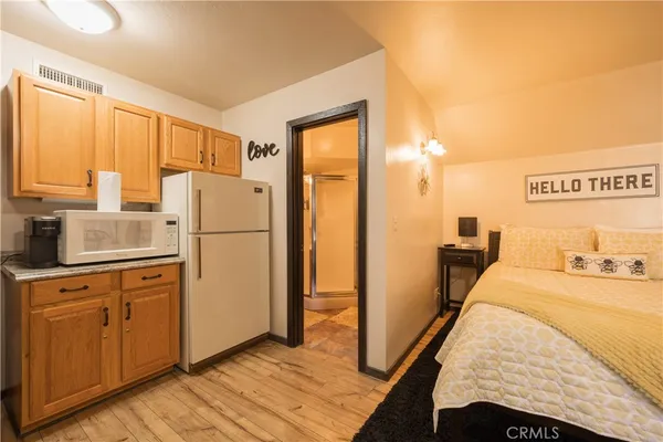 a bed room with a bed and a refrigerator