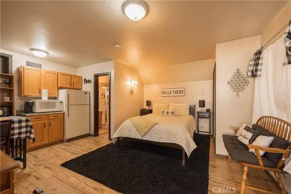 a large bedroom with a bed and wooden floor