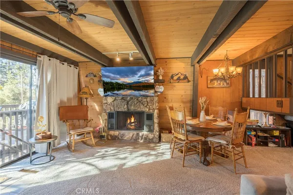 a living room with patio fireplace furniture and a floor to ceiling window