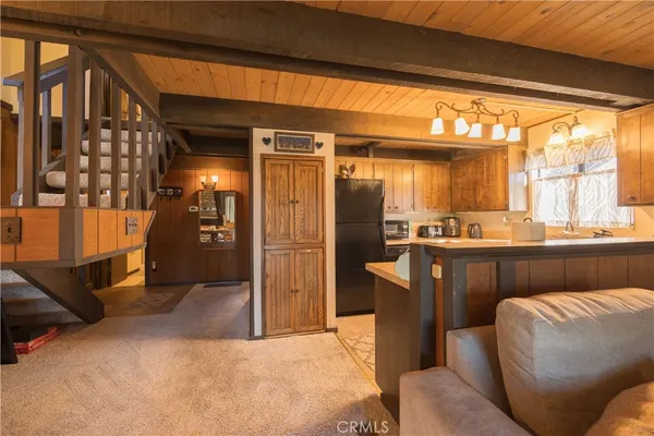 a living room with stainless steel appliances kitchen island granite countertop furniture and a large window