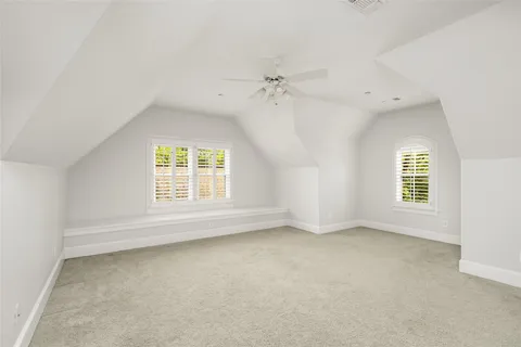 an empty room with a window and ceiling fan
