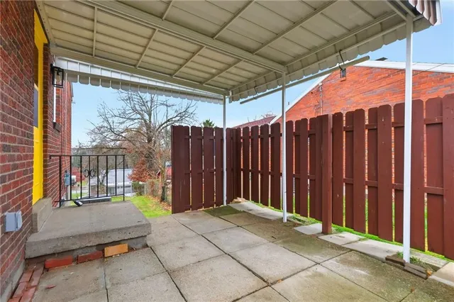a view of yard with tree and a wooden fence