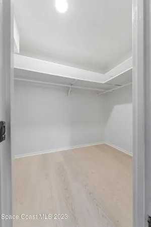 an empty room with a ceiling fan and window