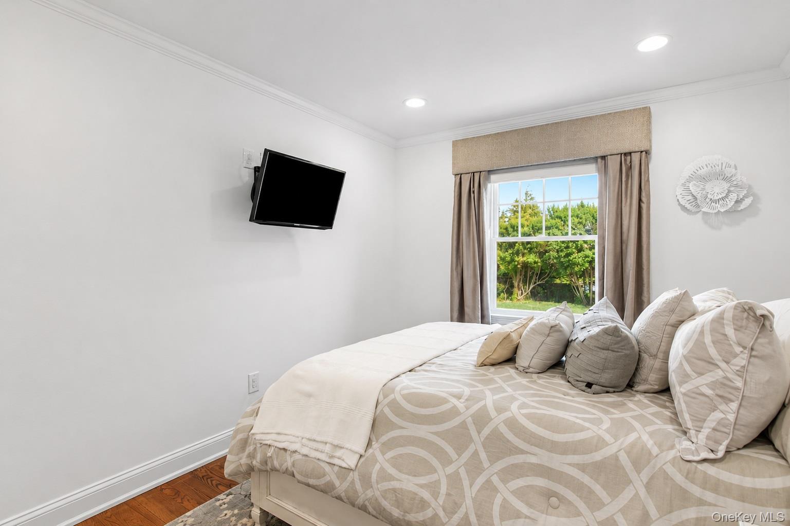 65 Shore Road Westhampton, NY 11977 - Photo 20 of 24 Bedroom featuring a large window, recessed lighting, crown molding, and wood flooring