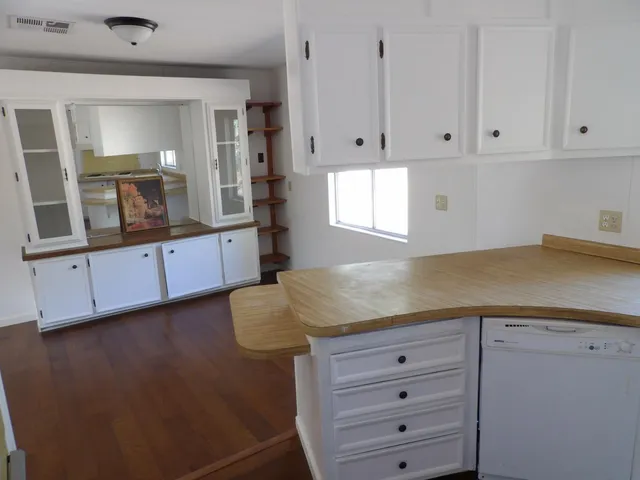 a kitchen with a refrigerator a sink and wooden floor