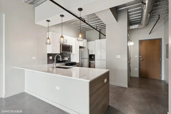 a large kitchen with stainless steel appliances kitchen island a refrigerator and a sink