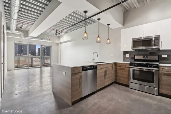 a large kitchen with stainless steel appliances granite countertop a sink and stove top oven