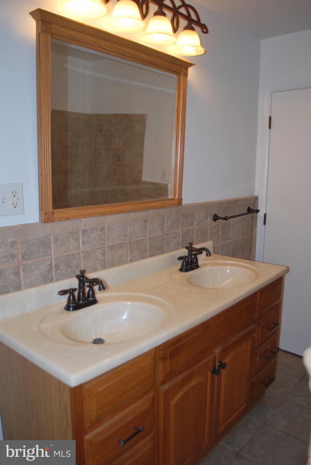 8263 Quarterfield Road Severn, MD 21144 - Photo 14 of 26 a bathroom with a sink and a mirror