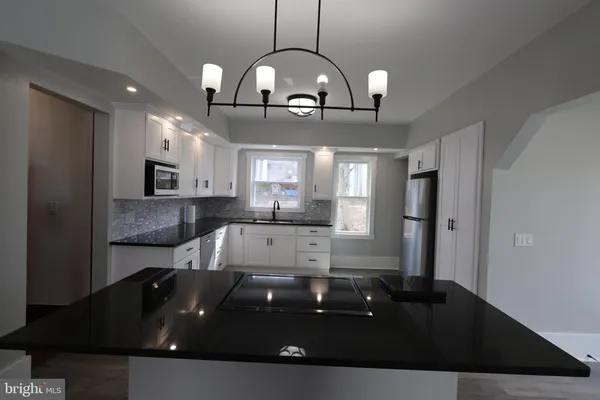 a view of a kitchen stove and microwave with wooden floor