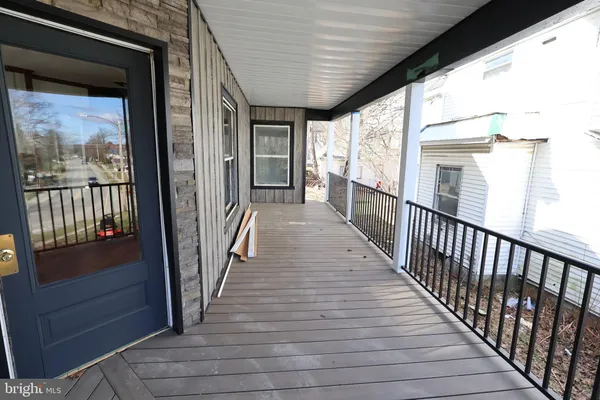 a view of a porch with wooden floor and furniture
