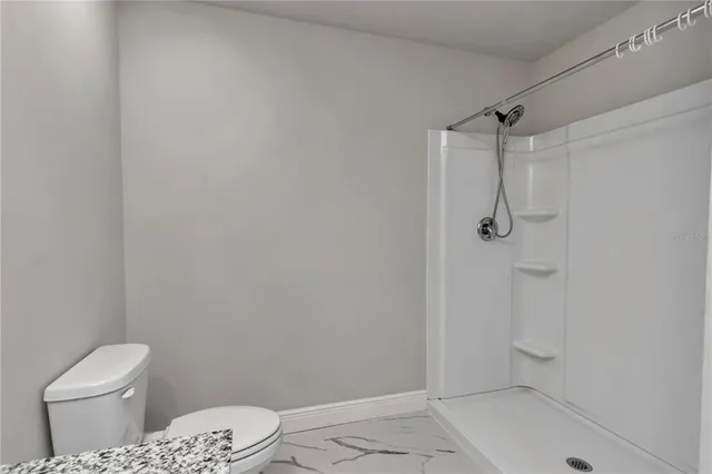 a bathroom with a toilet and a shower