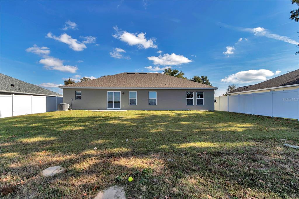 10090 Southeast 67th Terrace Belleview, FL 34420 - Photo 27 of 40 a view of a house with a backyard