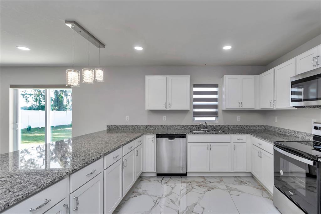 10090 Southeast 67th Terrace Belleview, FL 34420 - Photo 36 of 40 a kitchen with stainless steel appliances granite countertop a sink and window