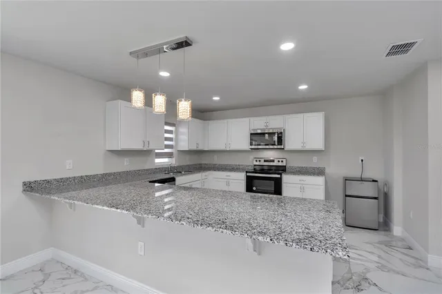 a kitchen with stainless steel appliances granite countertop a sink stove and cabinets