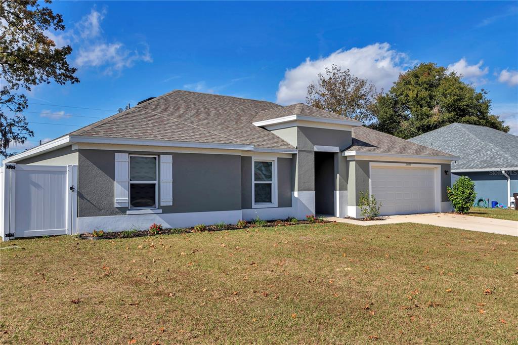 10090 Southeast 67th Terrace Belleview, FL 34420 - Photo 7 of 40 a front view of house with yard and trees in the background