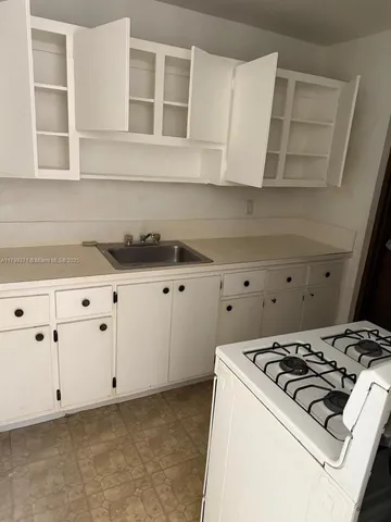 a stove top oven sitting inside of a kitchen