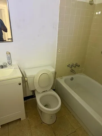 a white toilet sitting next to a bath tub