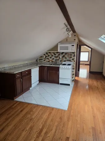 a large kitchen with stainless steel appliances granite countertop a stove and a wooden floors