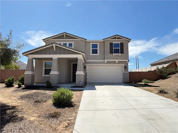 a front view of a house with a yard and seating space