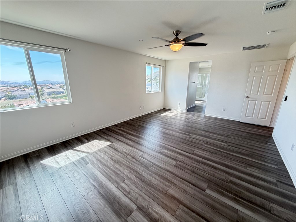 7483 Sage Scrub Road Riverside, CA 92507 - Photo 15 of 33 an empty room with wooden floor and windows
