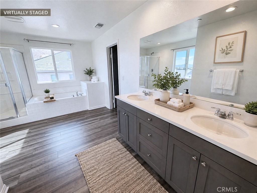 7483 Sage Scrub Road Riverside, CA 92507 - Photo 16 of 33 a spacious bathroom with a double vanity sink a large mirror and shower