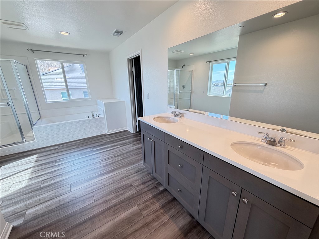 7483 Sage Scrub Road Riverside, CA 92507 - Photo 17 of 33 a spacious bathroom with a double vanity sink a mirror and a bathtub